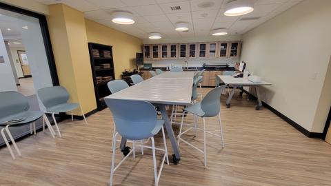 Photo shows a craft room with counter-height tables and chairs.