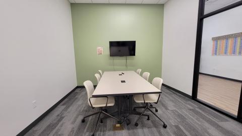 Photo shows a small room with a table and six chairs.