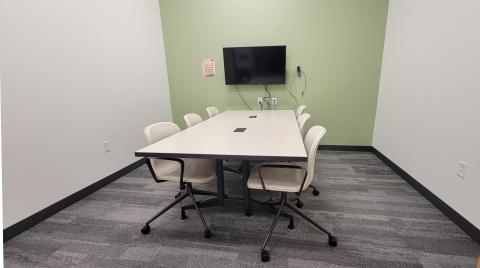 Photo shows a small room with a table and six chairs.